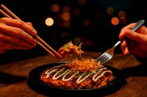 Persona comiendo okonomiyaki japonés en un restaurante nocturno 